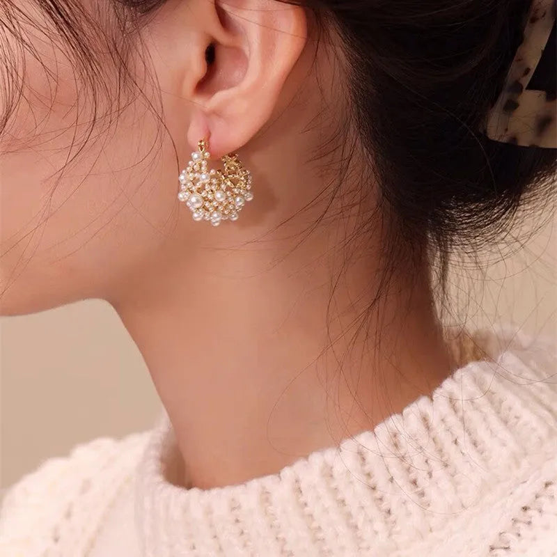 Gold-coloured copper flower basket earrings with small bead and pearl inlay detail.