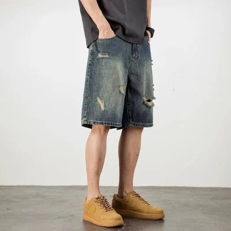 Blue denim men's shorts with distressed holes and straight cut design on mannequin