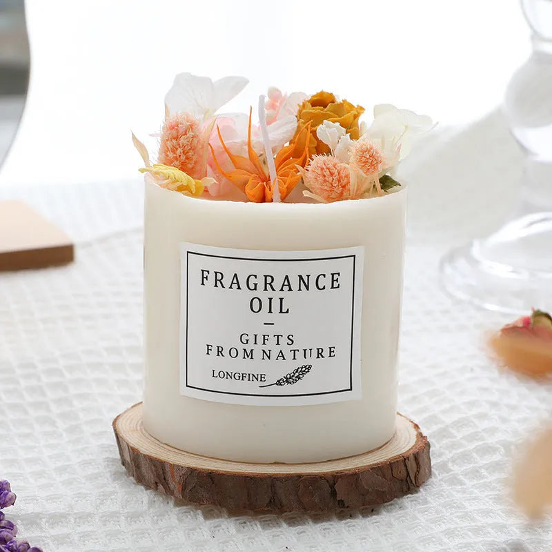 Aromatherapy candle decorated with dried flowers on top, shown in gift box packaging with a wood base.