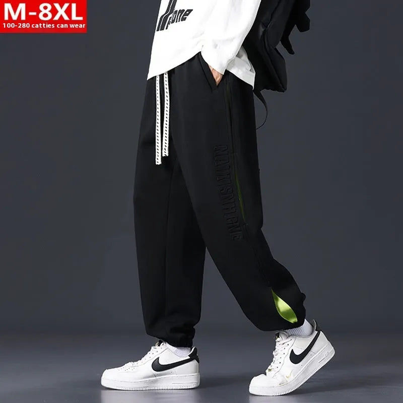 Men's loose grey green cotton trousers with ankle banding and stitching print detail on the leg.