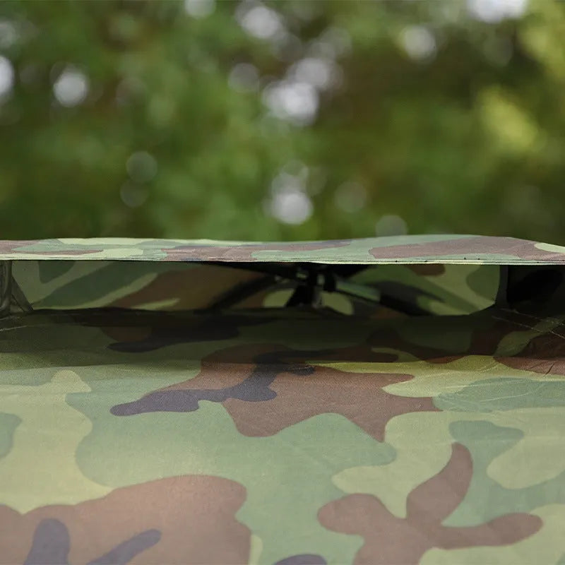 Double camouflage pattern tent pitched outdoors with triangular skylight visible