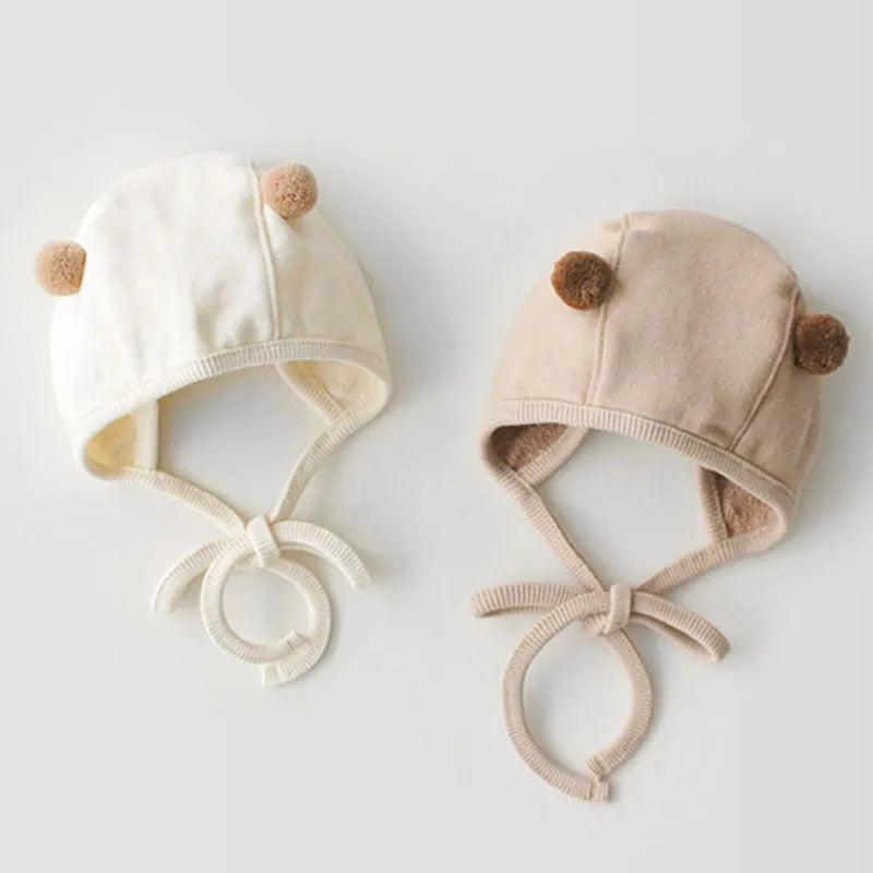Baby sleeveless cotton robe with detachable hood in white on a soft background