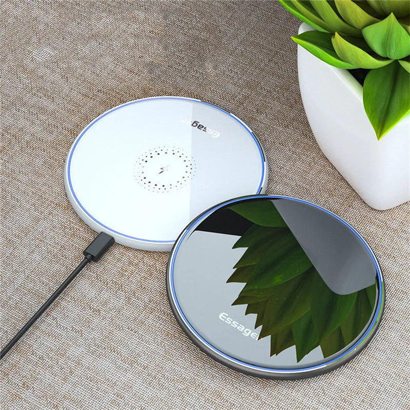 Black aluminium alloy Qi wireless fast charging pad for phones on a wooden desk.