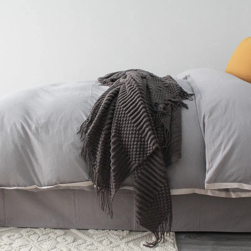 Small dark grey polyester nap blanket folded, showing its size of 127 cm by 170 cm.