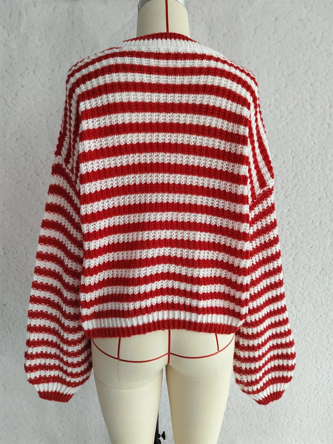 A woman wearing a vintage-style black and white striped loose-fit pullover sweater.
