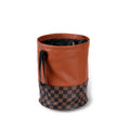 A retractable leather car trash can shown in a vehicle, featuring a carry handle.