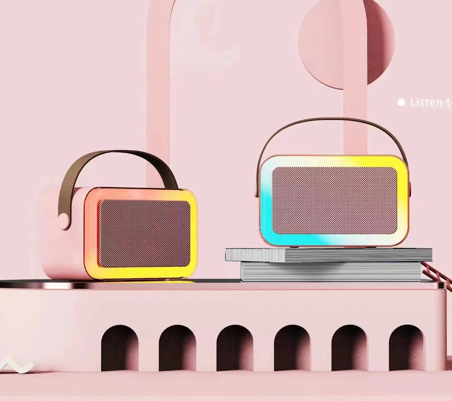 Pink portable Bluetooth karaoke speaker with microphone and coloured lights on a desk.