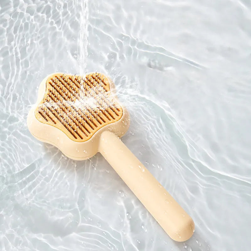 Green self-cleaning cat comb with stainless steel needle pins on a white background