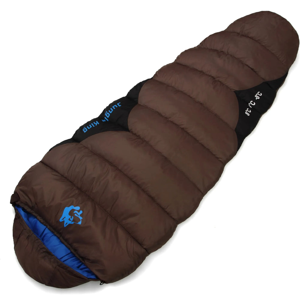Outdoor cotton sleeping bag in army green with its compression storage bag laid alongside.