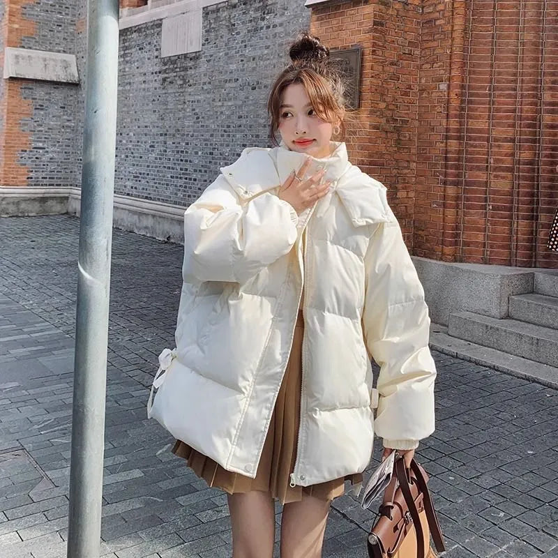 Women's loose black padded winter jacket with princess sleeves on a hanger.