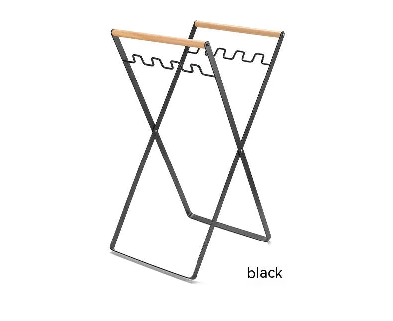 Black folding iron outdoor trash rack with a wooden handle standing upright.