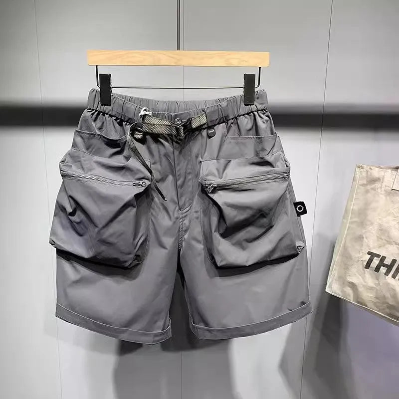 Man wearing large size black loose-fit work shorts with pockets, showing above-the-knee length.