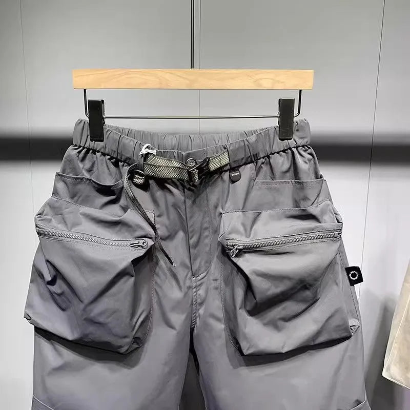 Man wearing large size black loose-fit work shorts with pockets, showing above-the-knee length.