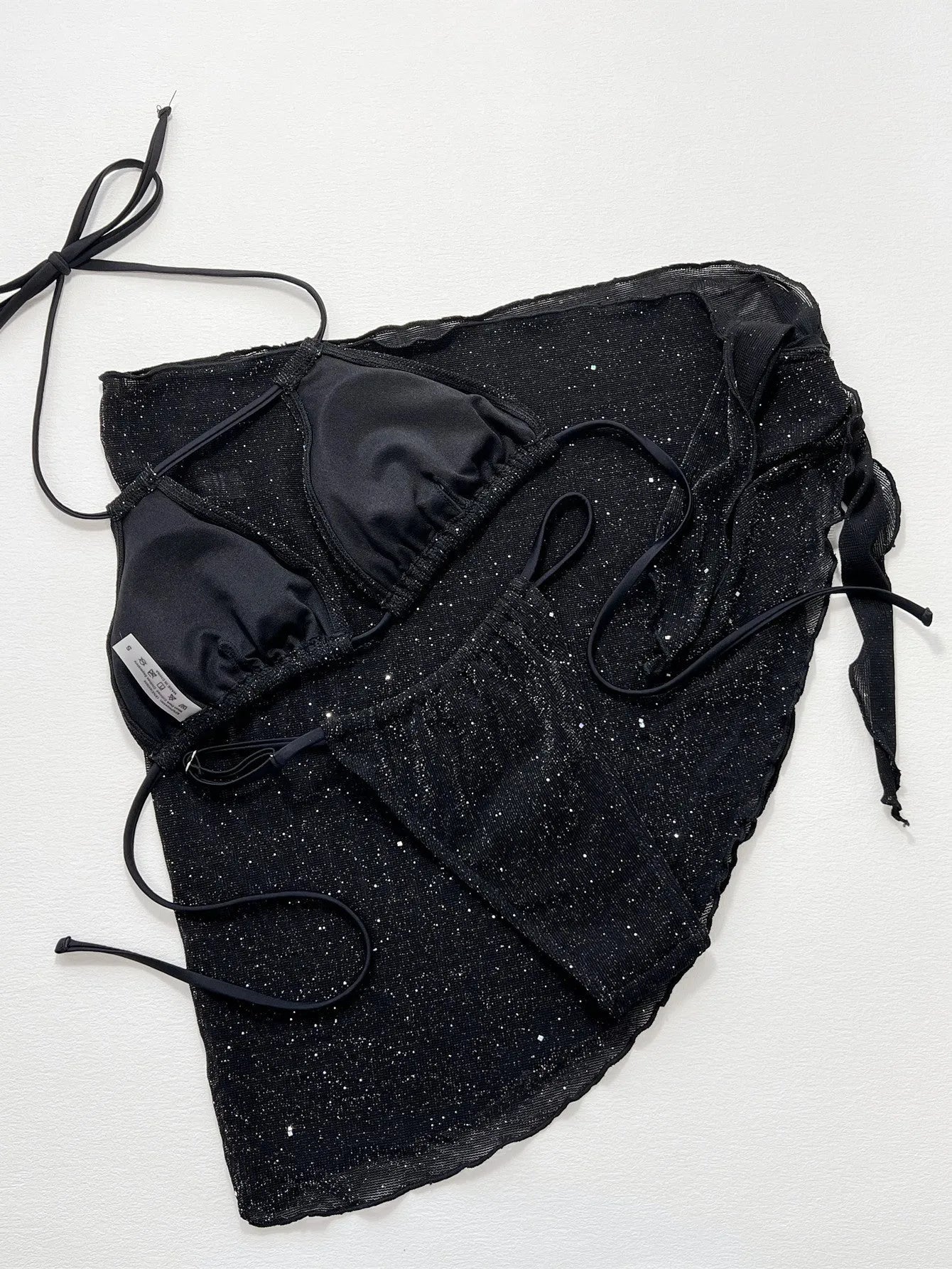 Black three-piece bikini swimsuit set with crop top and shorts on a mannequin.