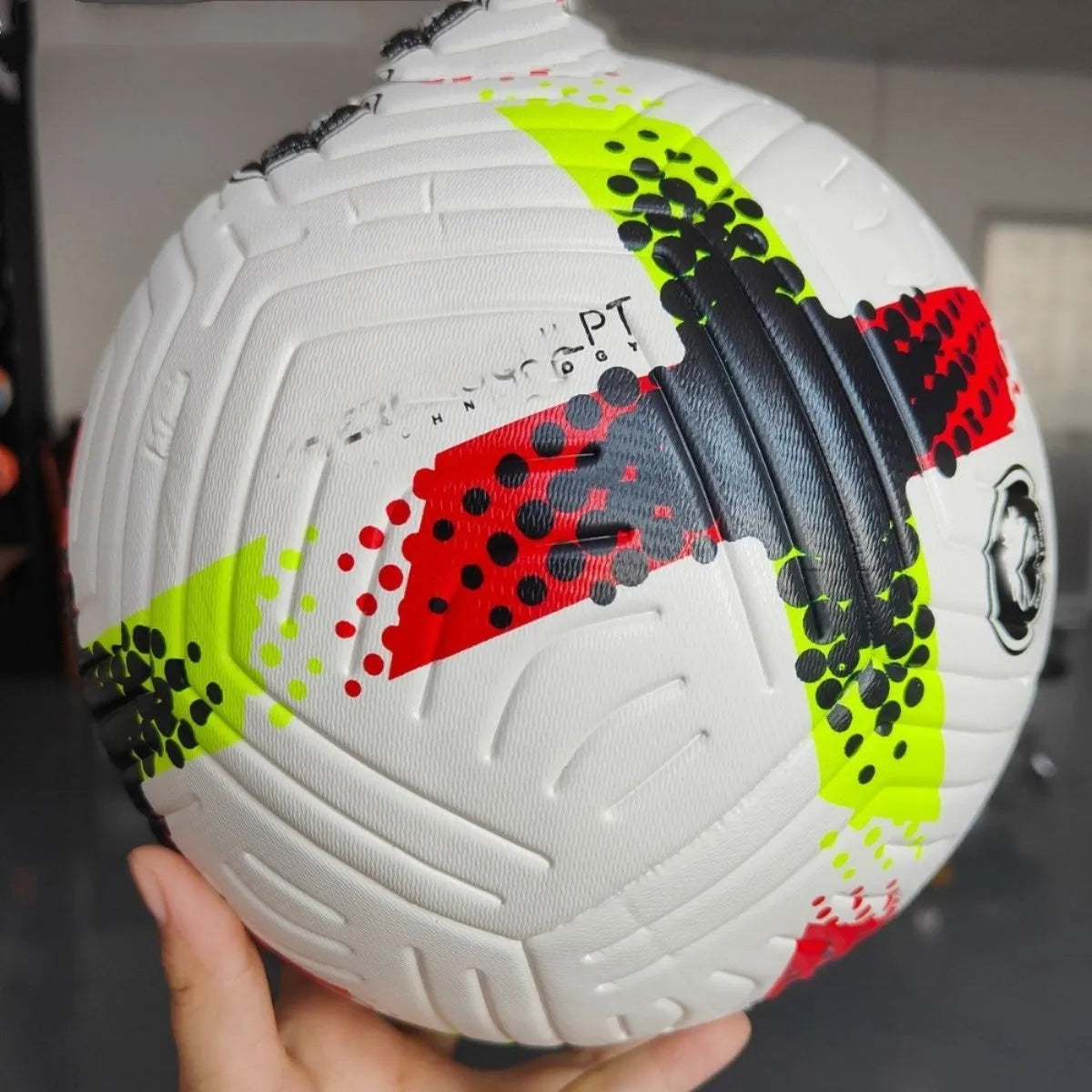 Fluorescent green size 5 PU football on a sports field