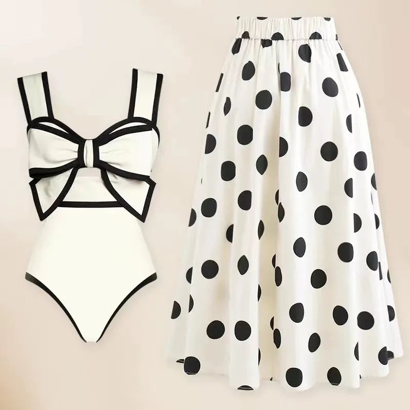 Women's black one-piece swimsuit with attached beach dress featuring a round skirt and bow detail.