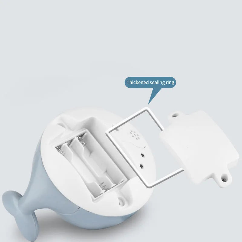 White and blue whale-shaped bath toy with water spray and LED lights floating in water