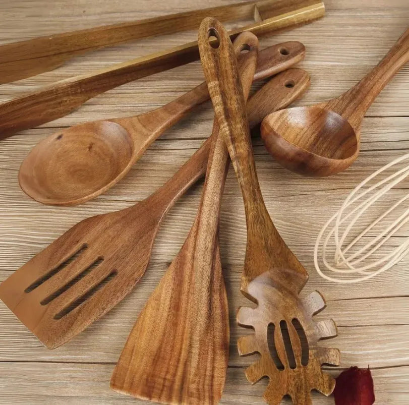A set of seven wooden cooking utensils including spoons and spatulas on a kitchen counter.