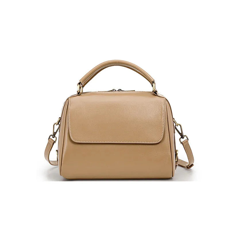 Women's soft cowhide leather crossbody tote bag in apricot colour, showing internal zip pockets and double shoulder strap.