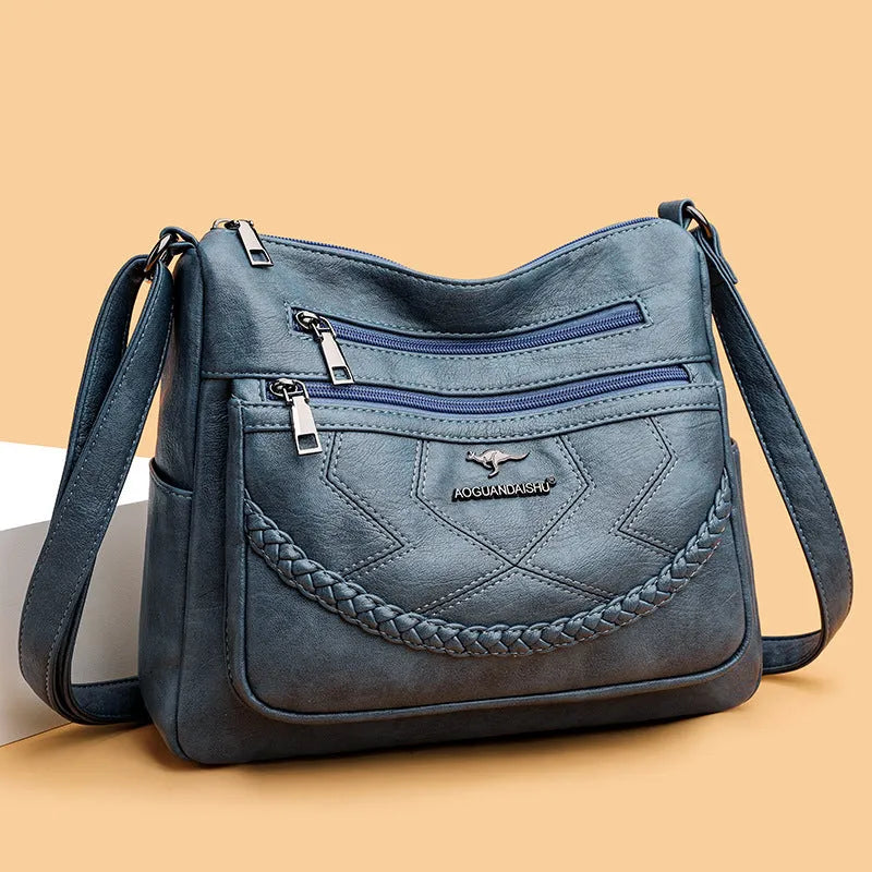 Soft PU leather shoulder bag in horizontal square shape, shown in one of four colours with crossbody strap