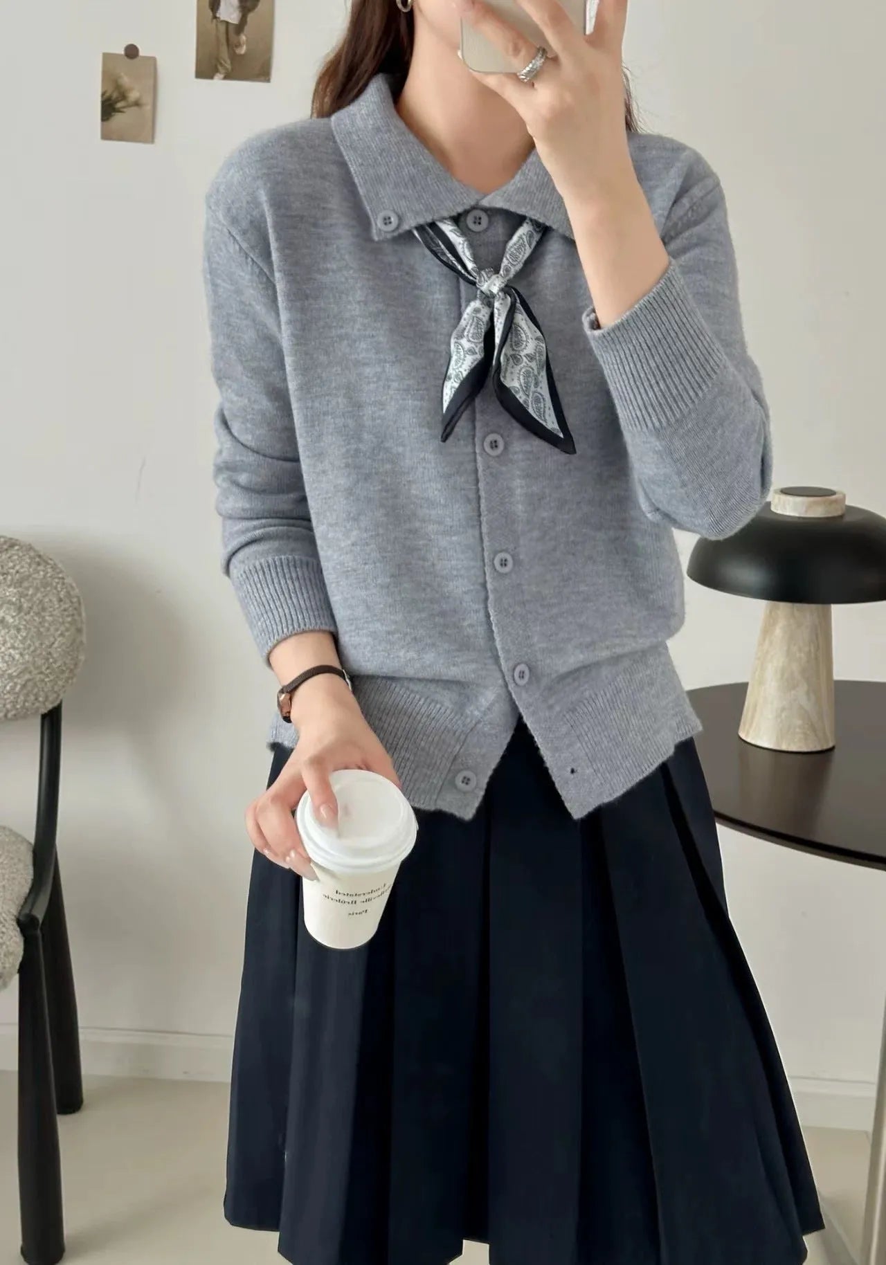 Beige cardigan sweater with attached lapel scarf and long sleeves on a model.