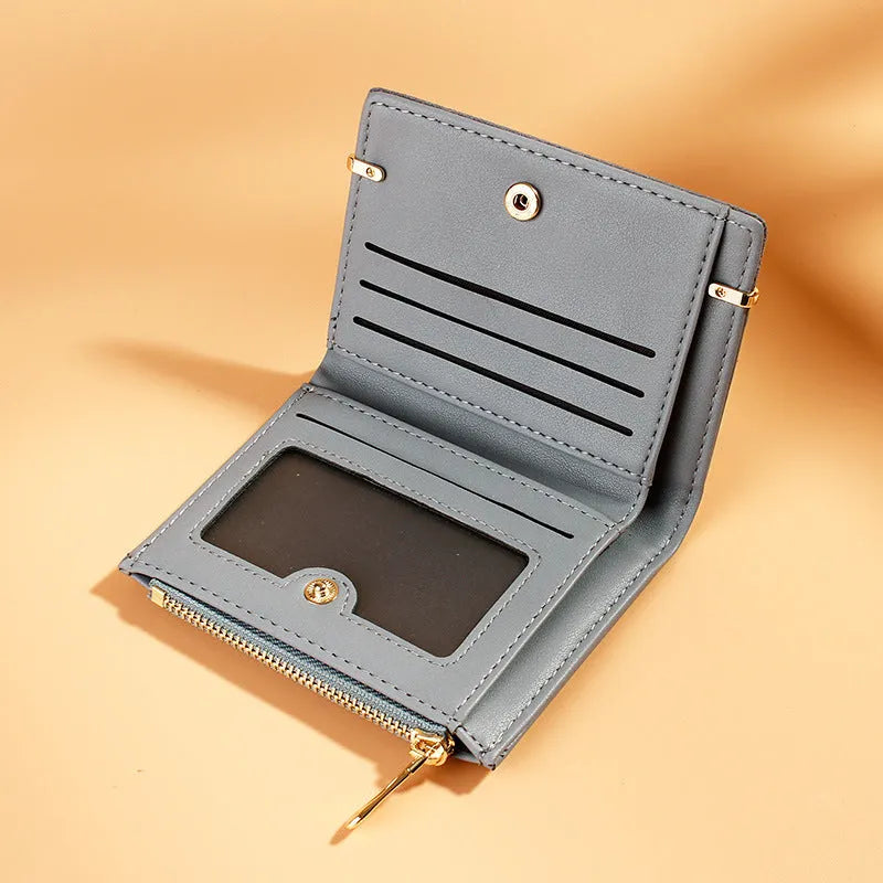 Black ladies folding wallet with a short zip, open to show multiple card slots, bill holder, and change compartment.