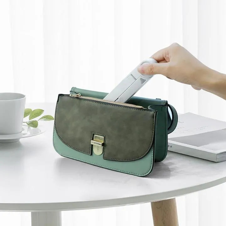 Black foldable tablet holder holding a smartphone in landscape mode on a desk.