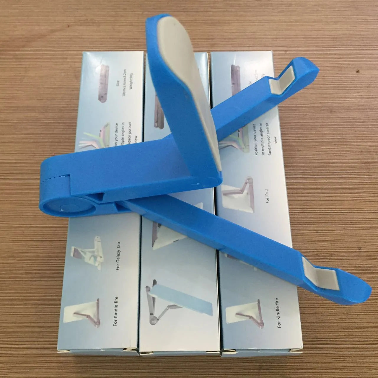 Black foldable tablet holder holding a smartphone in landscape mode on a desk.