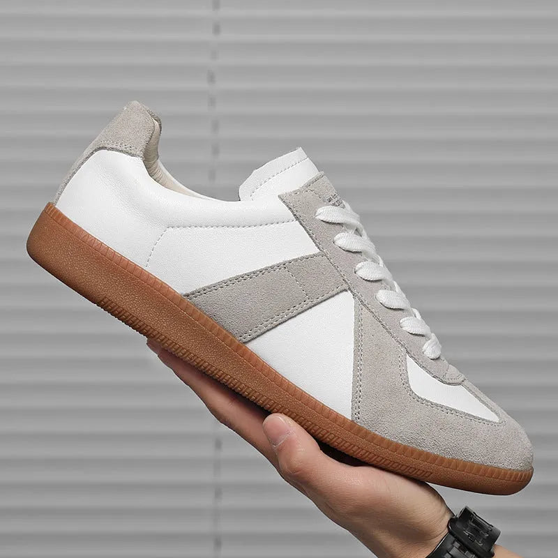 White retro unisex board sneakers with lace-up front and round toe on a rubber sole.