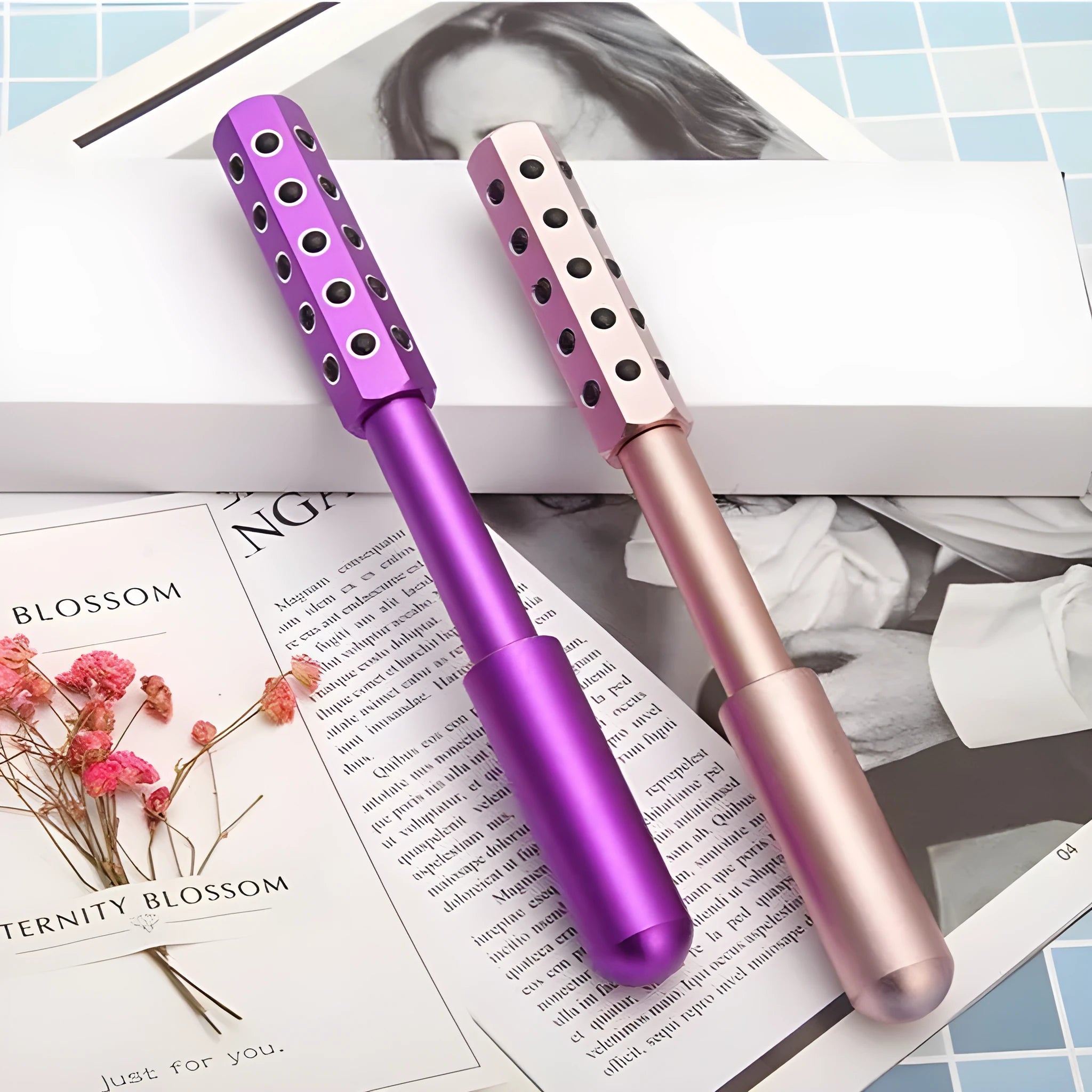 Purple stainless steel facial massage roller with germanium particle ball head on a white background.