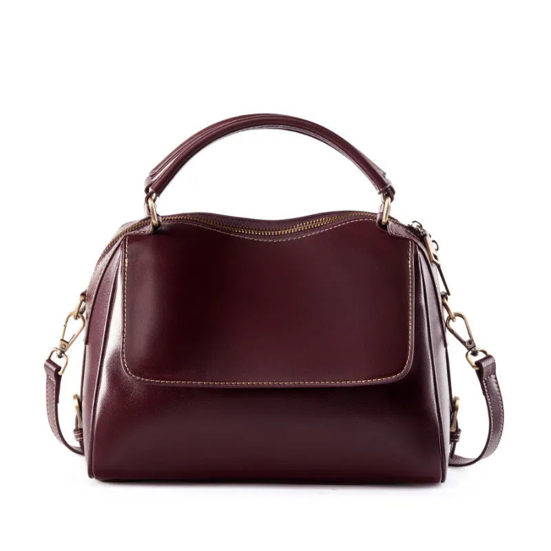 Women's soft cowhide leather crossbody tote bag in apricot colour, showing internal zip pockets and double shoulder strap.