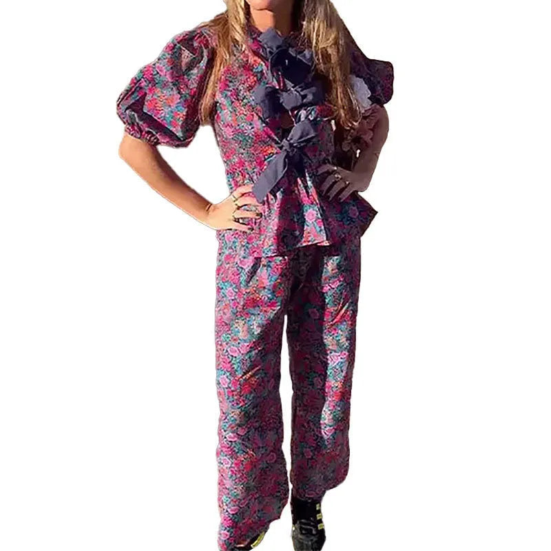 Women's floral print tie-neck trouser suit with puff sleeves, shown in the picture colour.