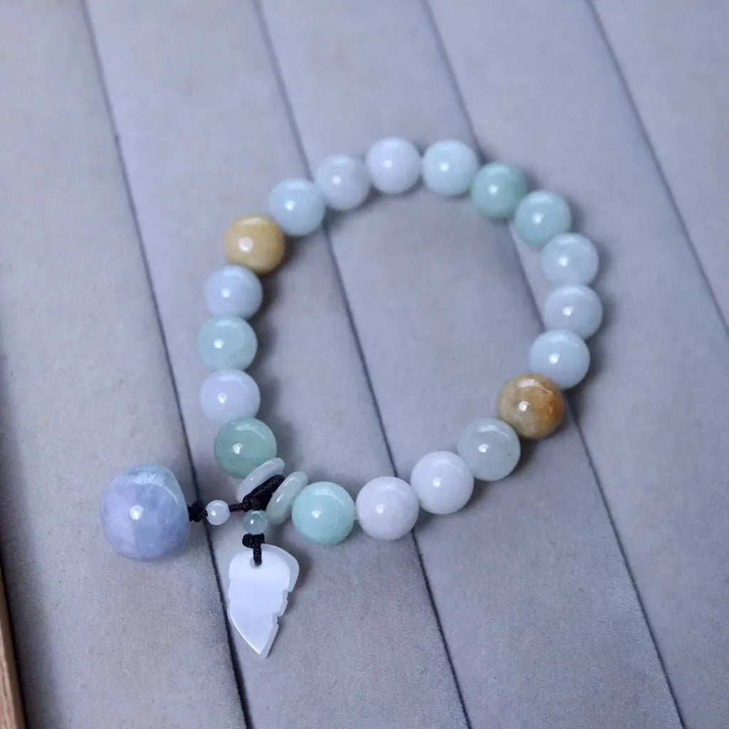 Natural green jade bracelet with hanging geometric charms including an Apple and a Maitreya Buddha pendant.