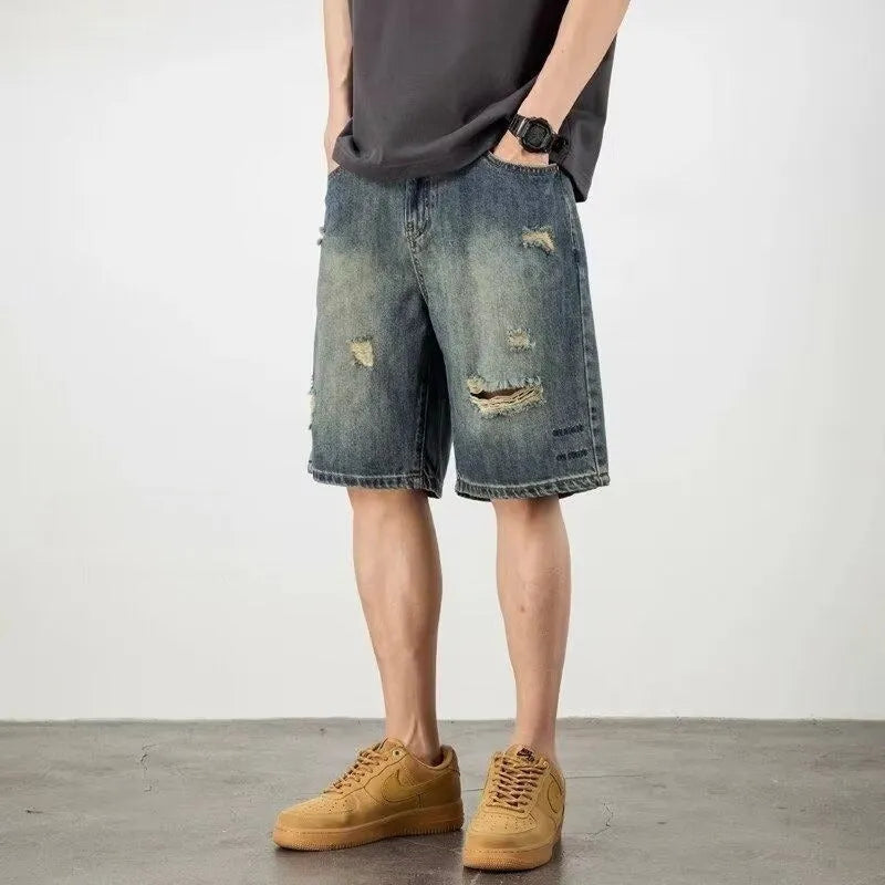 Blue denim men's shorts with distressed holes and straight cut design on mannequin