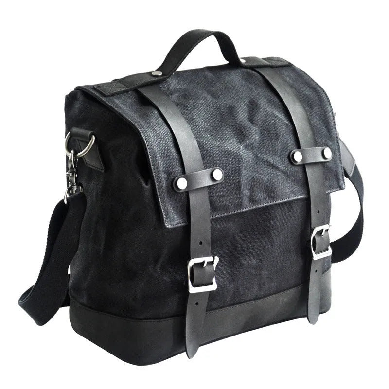Black waterproof canvas motorcycle side pannier bag with leather trim mounted on a bike
