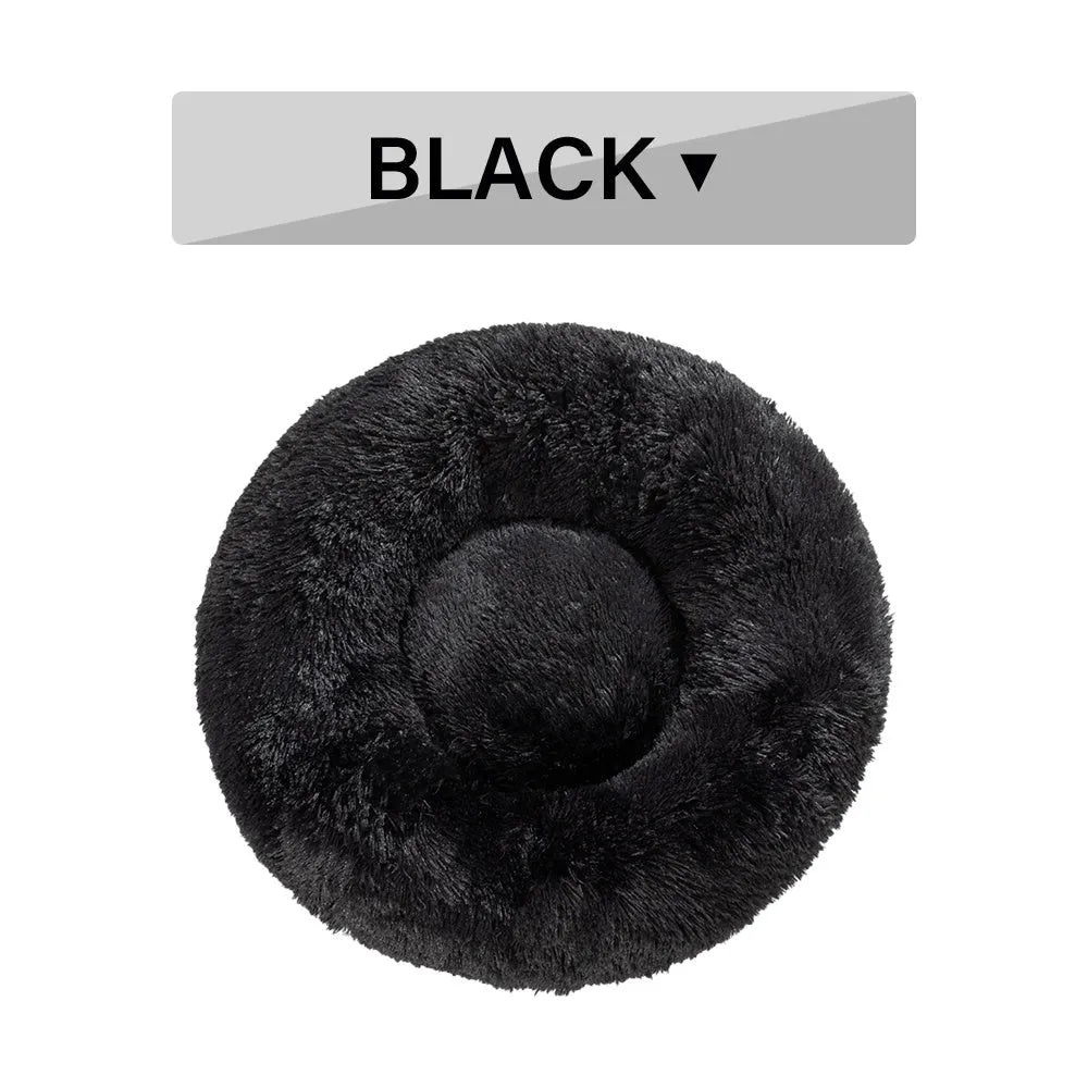 Fluffy donut-shaped dog bed in long plush fabric, shown in a light grey colour with a raised edge.