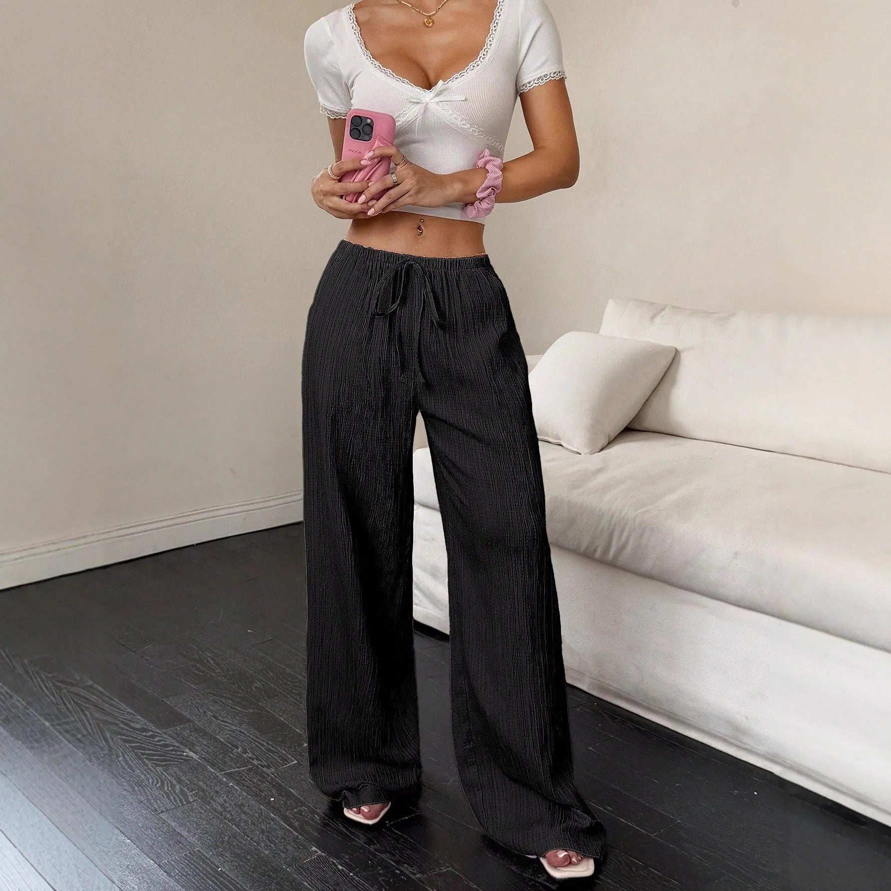 Women's black wide leg trousers with lace-up waist detail showing adjustable fit feature