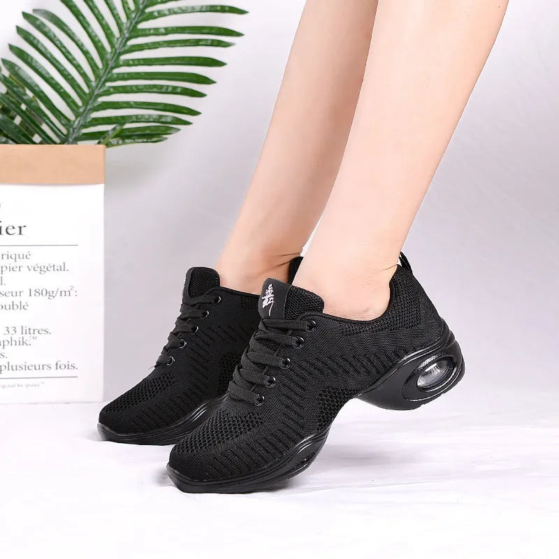 Women's white breathable fly woven mesh dance shoes with soft PU sole on a wooden floor.