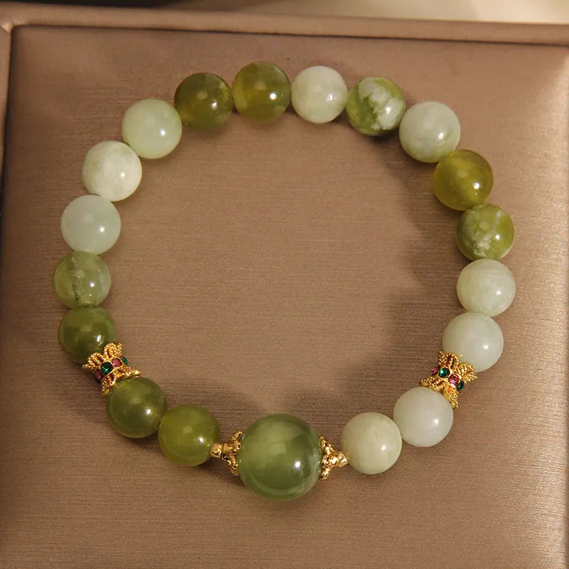 Xiuyan jade green women's bracelet with an original bangle design on a plain background.
