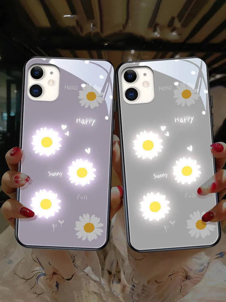 White daisy design voice-activated luminous TPU case for Apple iPhone on a table.