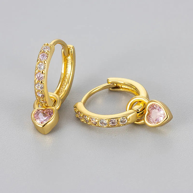 A pair of women's heart-shaped clip earrings with a coloured gemstone centre, available in gold or white gold colour metal.