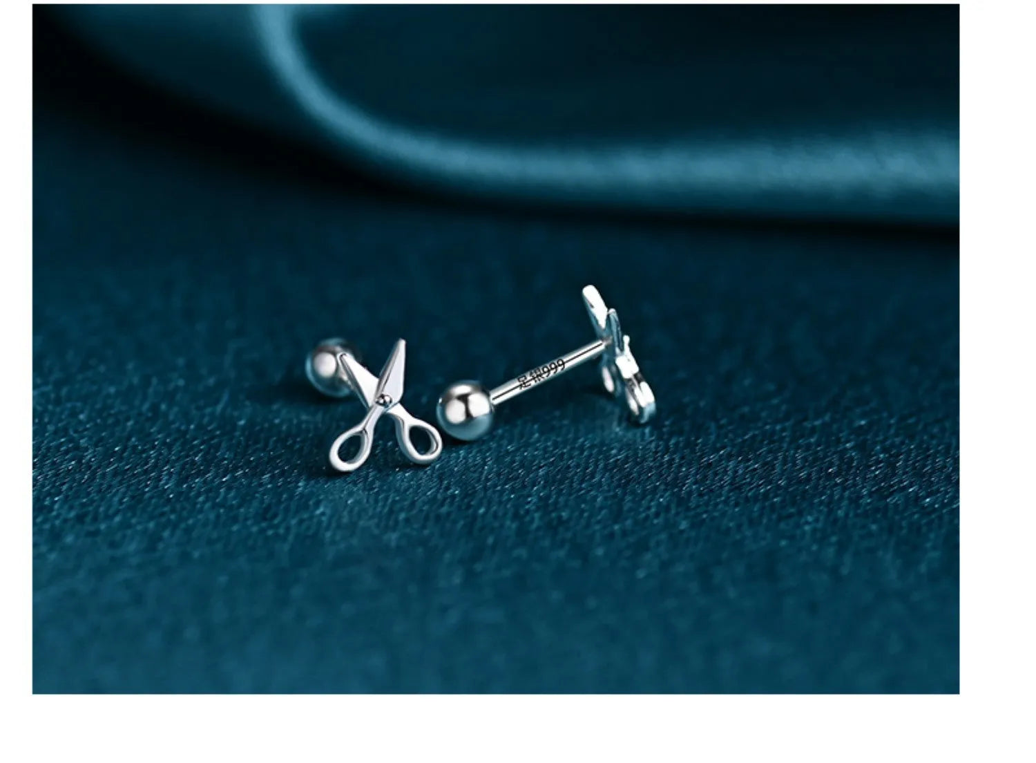 A pair of pure silver screw-style earrings for cartilage piercings with mini scissors screw details.