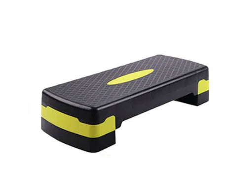 Grey, green, and orange fit step aerobics equipment on a plain background.