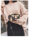 Hard black PU women's shoulder bag with flap closure and single adjustable cross-body strap.