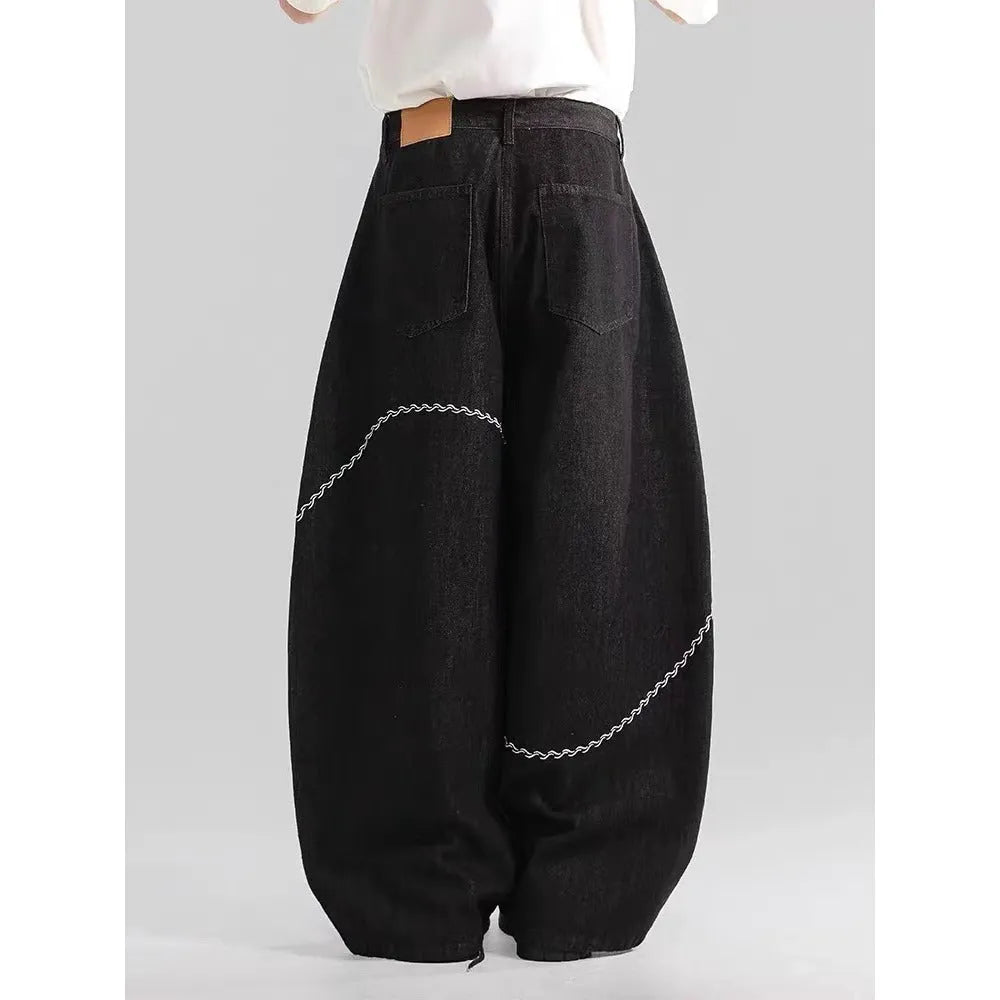 Black straight-leg denim trousers for teenagers on a hanger, showing mid-waist and zip fly detail.