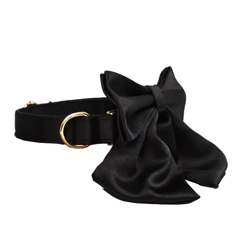 A soft cloth dog collar, leash, bow, and matching chest strap set laid out flat, showing coordinated colours.
