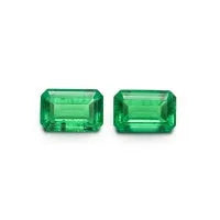Loose cultivated emerald gemstone in Columbia green colour showing round and fancy cut shapes on a white background.