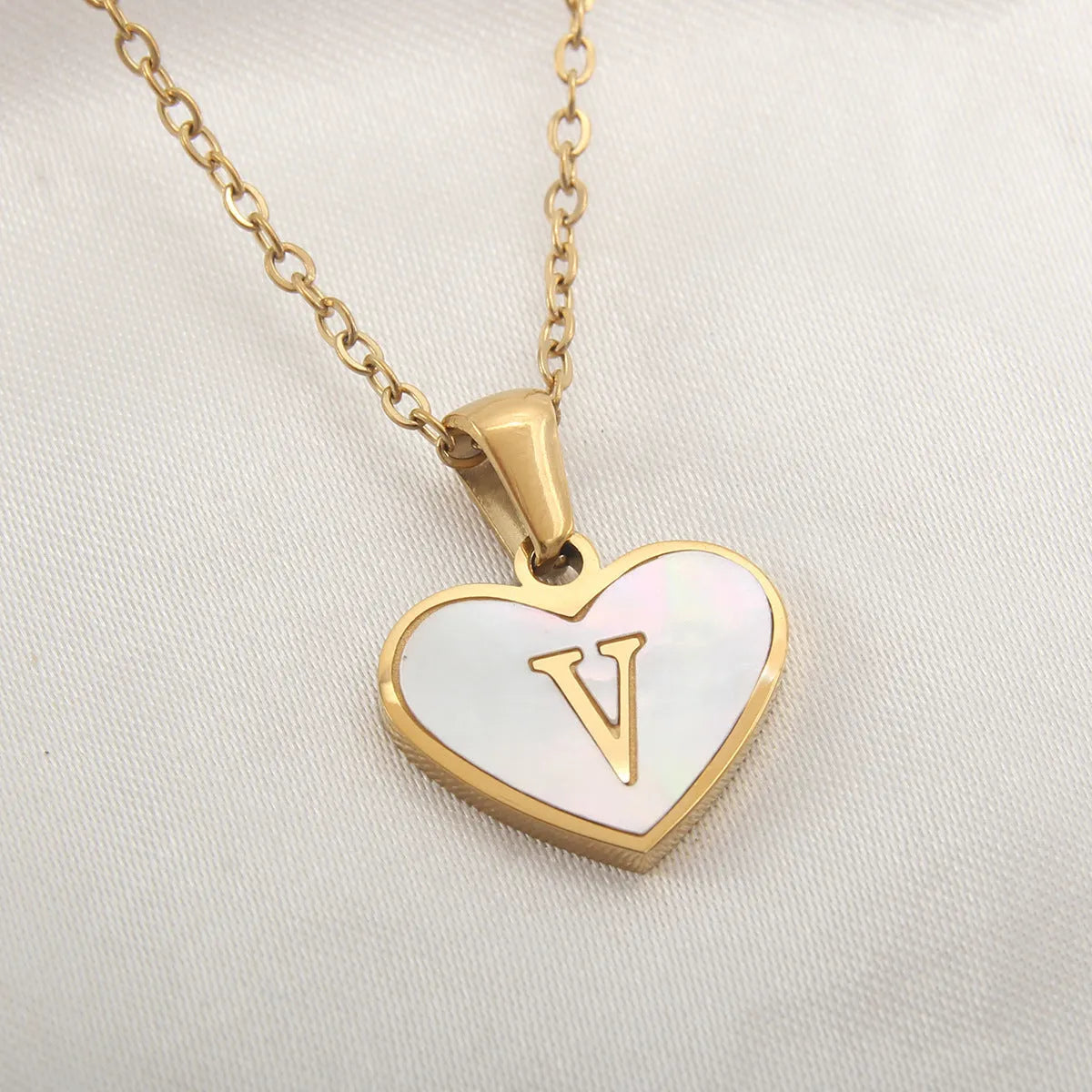 Gold plated heart-shaped white shell pendant personalised initial necklace on a stainless steel chain.