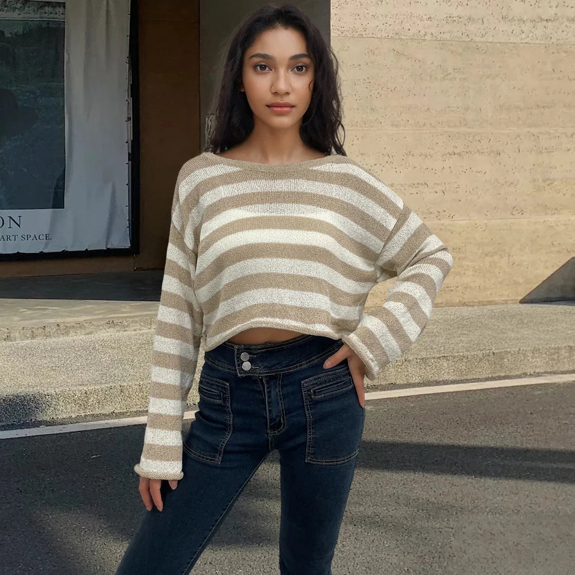 Striped long-sleeve women's pullover sweater in mercerised cotton showing exposed navel style.