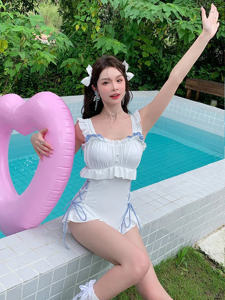 Women's milky white backless one-piece nylon swimsuit on a model.